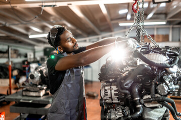 Professional mechanic repairing car engine in workshop