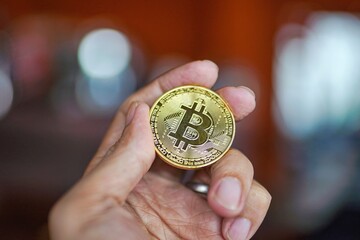 man hand holding bitcoin coin
