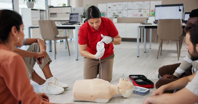 Mannequin, first aid and class with people and defibrillator for workshop, cardiac arrest and safety protocol. Healthcare, medical simulation and heart rhythm rescue with paramedic course in office