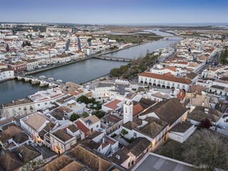 Obraz premium City view with roman bridge over Gilao river in old fishermen's town, Tavira, drone shot, Algarve, Portugal, Europe