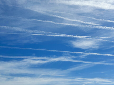 Blue sky with clouds and contrails