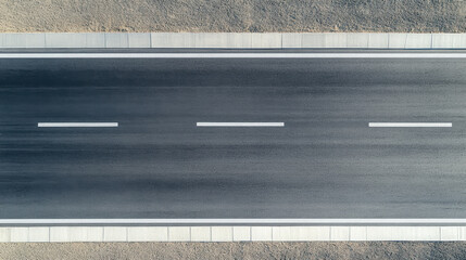 seamless top down view of modern asphalt highway with clear lane markings, showcasing smooth surface and surrounding gravel. image evokes sense of openness and tranquility