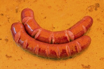 Two sausages swimming in oil