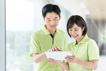 タブレットを持つ若い介護スタッフ