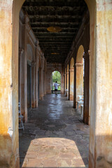 A man walks through the beautifully preserved old tunnel in Tha Rae, Sakon Nakhon, showcasing stunning ancient architecture and artwork from a bygone era.