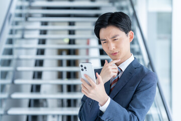 オフィスでスマホを使うビジネスマン