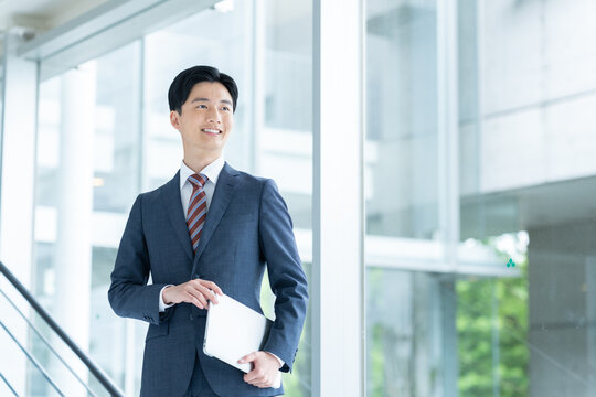 オフィスでパソコンを持つ若いビジネスマン