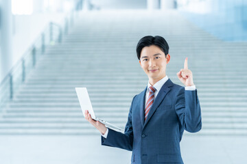オフィスでパソコンを持つ若いビジネスマン