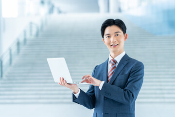 オフィスでパソコンを持つ若いビジネスマン