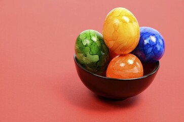 Colorful Easter eggs in a bowl with space for text