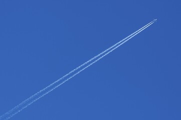 Plane with contrails in the blue sky, Germany, Europe