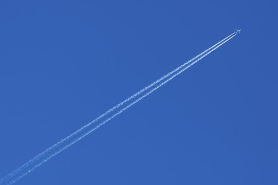 Plane with contrails in the blue sky, Germany, Europe