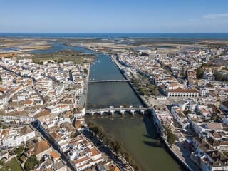 Obraz premium City view with roman bridge over Gilao river in old fishermen's town,Tavira, drone shot, Algarve, Portugal, Europe