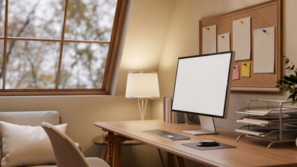 A close-up of a computer and decorative items on a hardwood desk in a warm, cozy room.