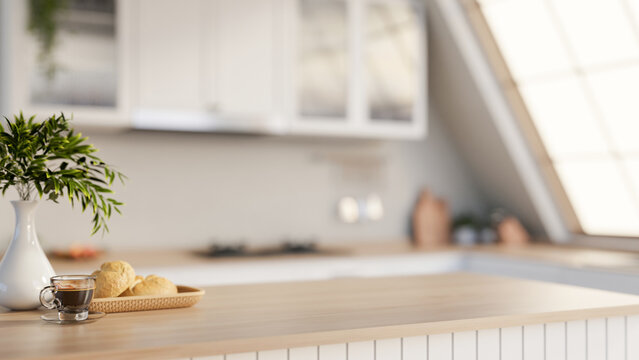 A minimalist hardwood kitchen tabletop adorned with decorative items, set in a sleek white kitchen.