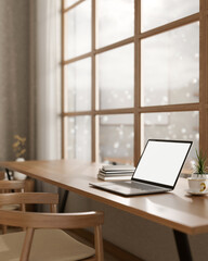 A laptop on a wooden table, positioned by a window with a snowy view, set in a cozy, minimalist cafe