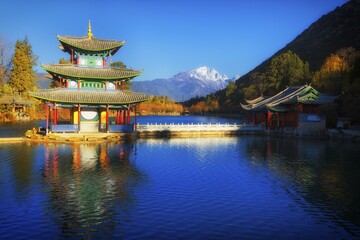 Obraz premium Chinese pagoda, Deyue Pavilion, reflected in Black Dragon Lake, Black Dragon Pool, in the background Jade Dragon Mountain, Unesco World Heritage Site, Lijiang, Yunnan Province, China, Asia