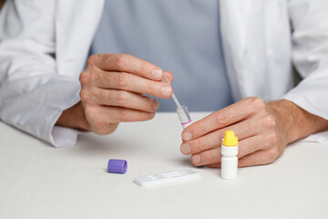 Male veterinarian practitioner doing medical sample rapid diagnostic test at examination room....