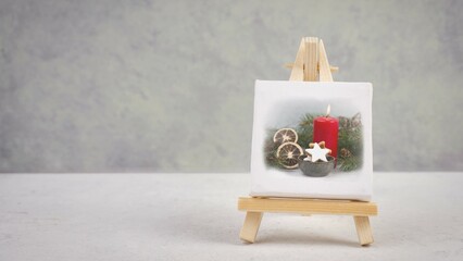 Advent wreath, christmas decoration with red candle light, drawing on an easel, copy space for text, holiday greeting card