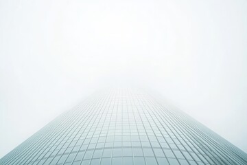 Skyscraper Reaching Into the Clouds: A Vertical Perspective of a Modern Glass Building Surrounded by Fog and Mist in an Urban Landscape