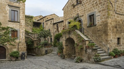 Old tufa buildings decorated with flowers in the hilltop village of Civita di Bagnoregio, Lazio, Italy, Europe