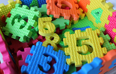 Scattered rubberized stencils with colored cut out numbers. Colorful 3d puzzles with numbers