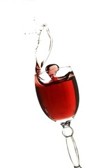 Splashing glass of red wine on a white background