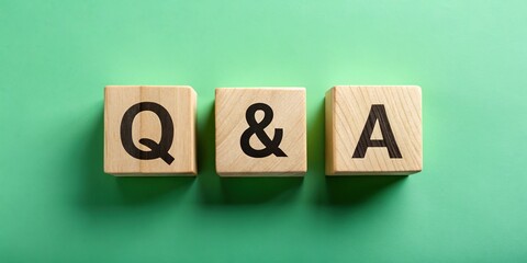 Obraz premium Aerial View of Wooden Q&A Blocks on Green Background - Question and Answer Concept