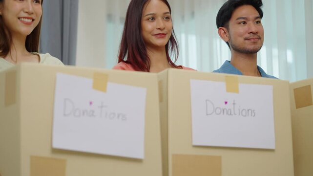 group of asian young adults tanding together, each holding a donation box with a handwritten sign. community support, and charitable giving