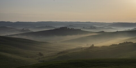Hilly landscape with foggy atmosphere and country estate, morning light, Tuscany, Siena province, Italy, Europe