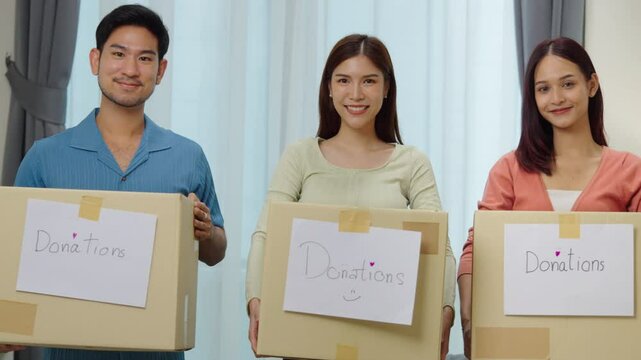 group of asian young adults tanding together, each holding a donation box with a handwritten sign. community support, and charitable giving