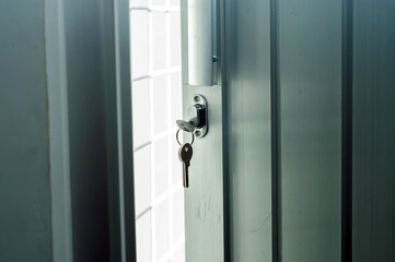 door lock with a key that hangs on the aluminum door