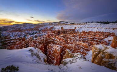 Amphitheatre at sunrise, snow-covered bizarre rocky landscape with Hoodoos in winter, Rim Trail,...