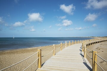 Obraz premium Wooden footbridges at the beach of Riumar, Ebro Delta Nature Reserve, Tarragona province, Catalonia, Spain, Europe