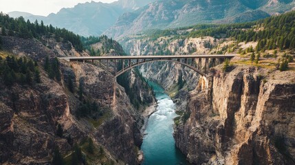 bridge crossing a river surrounded by mountains.