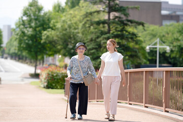 A park with good atmosphere with canal in Toyama Prefecture. Old woman in her 90s and Japanese woman in her thirties are walking around the park.