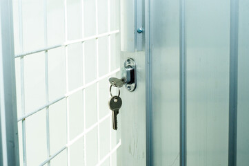 door lock with a key that hangs on the aluminum door