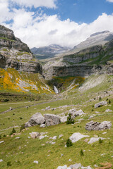 A breathtaking view of a lush mountain valley with a waterfall in Ordesa y Monte Perdido National Park, Spain. A perfect destination for trekking, hiking, mountaineering, and summer outdoor adventures © Martí Rosselló