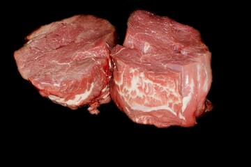 Two beef fillets ready for roasting, studio photography with black background