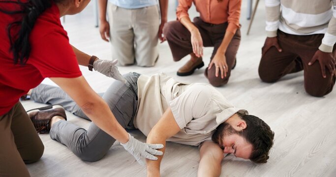 People, demonstration and class for first aid, teaching or recovery position to prevent aspiration. Floor, life saving and learning to rescue person with seizure, healthcare or side technique for CPR