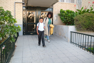 Mother and son walking together outside their home
