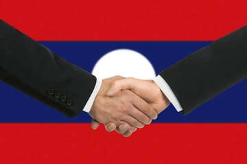 The Laotian flag and business handshake