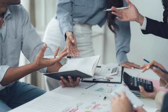 Collaborative Brainstorming Session: A close-up shot focusing on hands and documents during an engaging brainstorming session. Colleagues actively participate, ideas flow freely.