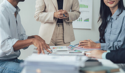 Strategic Collaboration: A diverse team of professionals engaged in a focused business meeting, reviewing financial data and collaborating on a project.