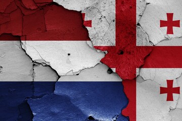 Flags of Netherlands and Georgia painted on cracked wall