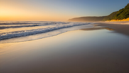 A peaceful sunrise casting golden light on a calm beach
