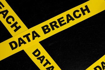 Data breach alert, caution and warning concept. Yellow barricade tape with word in dark black...