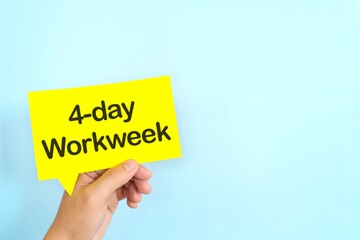 Human hand holding yellow speech bubble with written 4-day work week. 