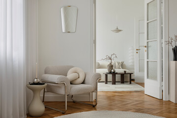 Elegant living room featuring a boucle armchair, abstract artwork, and soft furnishings. A calm and...