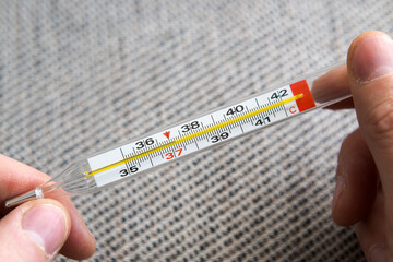 Measuring body temperature with a classic thermometer, health and medicine.
